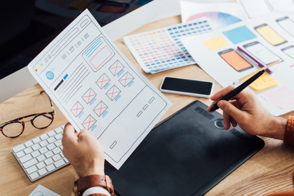 cropped view of designer using graphics tablet while planning user experience design of website at e1679884084172