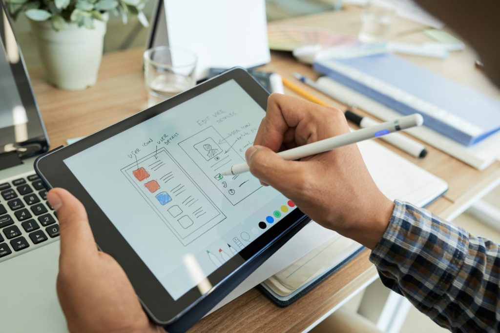ui designer drawing sketch of mobile app e1679884076277